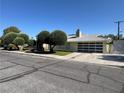Lovely home featuring a modern garage door, manicured lawn, and mature trees, providing a welcoming atmosphere at 1819 Beverly Way, Las Vegas, NV 89104