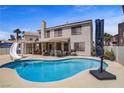 Backyard featuring a large swimming pool, covered patio with seating, and landscaped surroundings at 270 Snowy River Cir, Henderson, NV 89074