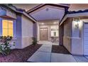 Inviting front entrance with double doors, a cozy sitting area, and well-manicured landscaping at 2725 Cool Lilac Ave, Henderson, NV 89052