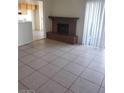 Open-concept living room with a brick fireplace, tile flooring, and sliding glass door leading to a patio at 2981 Country Manor Ln # 118, Las Vegas, NV 89115