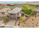 A two-story house with a desert landscape, artificial turf backyard, and a nearby school with soccer fields at 438 Wind Poppy St, Las Vegas, NV 89138
