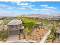 This two-story home features desert landscaping, a view of the mountains, and an artificial turf backyard at 438 Wind Poppy St, Las Vegas, NV 89138