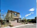 Beautiful two-story home showcasing a neutral color, complemented by a brick driveway and desert landscaping at 438 Wind Poppy St, Las Vegas, NV 89138