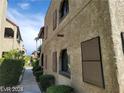 Exterior view of a condo building with a red tiled roof and lush landscaping at 4720 Obannon Dr # D, Las Vegas, NV 89102