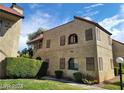Charming condo building featuring a red tile roof and lush green landscaping at 4720 Obannon Dr # D, Las Vegas, NV 89102