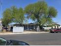 A single-story home features a yard with mature trees and a chain-link fence at 4794 Saguaro Way, Las Vegas, NV 89121