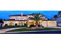 Elegant home showcasing lush landscaping, arched windows, and attached garage at 5030 Spanish Hills Dr, Las Vegas, NV 89148
