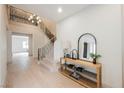Inviting foyer with staircase, hardwood floors, stylish console table, decor and elegant chandelier at 516 Pinnacle Heights Ln, Las Vegas, NV 89144