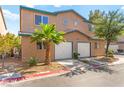 Inviting townhome with a two-car garage, desert landscaping, and manicured curb appeal at 5615 Calais Ct, Las Vegas, NV 89118