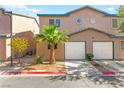 Inviting townhome features a two-car garage, desert landscaping, and modern architectural details at 5615 Calais Ct, Las Vegas, NV 89118