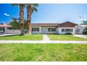 Classic single-story home featuring a lush green lawn, mature trees, and a welcoming entrance at 633 5Th St, Boulder City, NV 89005
