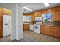 Bright kitchen with wood cabinets, white appliances, and tile flooring with an adjacent refrigerator at 633 5Th St, Boulder City, NV 89005