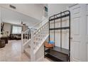 Bright entryway with coat rack, staircase with white railing, and an open view into the living room at 6334 Orions Belt Peak St, North Las Vegas, NV 89031