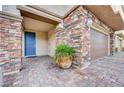 Charming covered entryway with stone pillars, brick pavers, a blue front door, and desert landscaping at 6334 Orions Belt Peak St, North Las Vegas, NV 89031