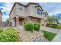Two-story home exterior with stone accents, desert landscaping, brick paver driveway and walkway, and a covered entryway at 6334 Orions Belt Peak St, North Las Vegas, NV 89031