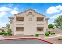 Neutral-colored condo building showcasing the architecture and design of the complex under a bright blue, cloudy sky at 855 N Stephanie St # 2121, Henderson, NV 89014