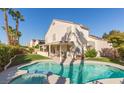 Beautiful backyard featuring a private pool, lush landscaping, and covered patio at 9485 Supernova Ct, Las Vegas, NV 89123