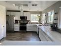 Bright kitchen featuring white cabinetry, modern appliances, quartz countertops and luxury flooring at 9485 Supernova Ct, Las Vegas, NV 89123