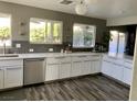 Modern kitchen featuring white cabinets, stainless steel appliances, and gray backsplash at 9485 Supernova Ct, Las Vegas, NV 89123