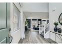 Inviting entryway with light grey wood floors, a staircase and a view into the modern living spaces at 9576 Archer Peak Ct, Las Vegas, NV 89143