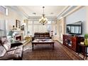 Relaxing living room with a cozy fireplace, coffered ceilings and plush leather seating at 10125 Hope Island Dr, Las Vegas, NV 89134