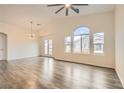 Bright, open living room featuring high ceilings, large windows, a modern ceiling fan and wood-style flooring at 10147 Aspen Rose St # 101, Las Vegas, NV 89183