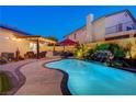 Resort-style backyard featuring a refreshing pool, outdoor kitchen, patio, and lush landscaping at 1028 Dodger Blue Ave, Las Vegas, NV 89123