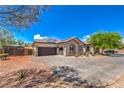 Charming home featuring a paved driveway, a three car garage, desert landscaping and solar panels at 10319 Larkmead Ave, Las Vegas, NV 89149