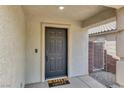 Image showcases the front door with a 'hello, goodbye' door mat, accompanied by neutral exterior finishes at 10554 Lilac Tree Ave, Las Vegas, NV 89135