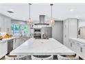 Bright kitchen featuring a large marble island, stainless steel appliances and modern pendant lighting at 108 Quail Run Rd, Henderson, NV 89014