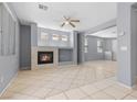 Spacious living room boasts tile floors, natural light, a modern fireplace, and a ceiling fan at 180 Duck Hollow Ave, Las Vegas, NV 89148