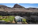 Scenic aerial view of a single-story home nestled against a stunning mountain backdrop at 1957 Regal Bluff Dr, Henderson, NV 89052