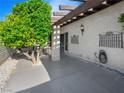 Inviting covered patio with pergola, tiled floors, iron accents, decorative sconce, and view of the landscaped yard at 2104 Plaza De La Candela, Las Vegas, NV 89102