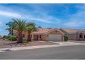 Inviting single-story home with mature landscaping, tile roof, and a convenient two-car garage at 3040 Hidden Treasure Dr, Las Vegas, NV 89134