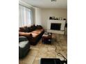 Cozy living room featuring a decorative fireplace, tile flooring, and natural light at 3382 Berwyck St, Las Vegas, NV 89121