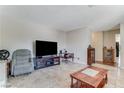 View of the cozy living room with tile flooring and an entertainment center, ideal for relaxation at 3382 Berwyck St, Las Vegas, NV 89121