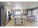 Spacious kitchen with stainless steel appliances, custom island, and cozy breakfast nook at 3404 Brayton Mist Dr, North Las Vegas, NV 89081
