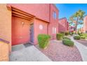 Condominium exterior with grey door and tidy landscaping at 4050 Pacific Harbors Dr # 107, Las Vegas, NV 89121