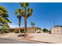 Charming single-story home featuring a spacious driveway, two palm trees, and a two-car garage at 502 E Fairway Rd, Henderson, NV 89015