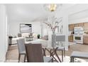 Dining area with modern chandelier, open to the staged living room and a bright kitchen at 5513 Escallonia St, Las Vegas, NV 89149