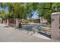 Inviting gated entrance with mature landscaping and a sprawling driveway at 5854 Sheila Ave, Las Vegas, NV 89108