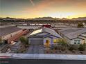 Home featuring solar panels, a two-car garage, and desert landscaping against a scenic mountain backdrop at 617 Sylvan St, Henderson, NV 89002