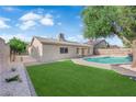 Inviting backyard featuring a sparkling pool, lush lawn, and mature trees at 6791 Greengrove Dr, Las Vegas, NV 89103