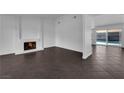 Bright living room with a cozy fireplace, tile flooring and sliding door to pool at 6791 Greengrove Dr, Las Vegas, NV 89103