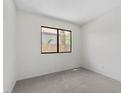 The bedroom offers neutral walls, plush carpet, and a window framing serene outdoor views at 6997 Ray Charles Ln, Las Vegas, NV 89119