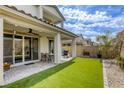 Inviting backyard featuring a covered patio, lush green lawn, and charming landscaping at 7061 Tilligerry St, North Las Vegas, NV 89084