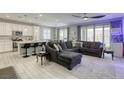Open-concept living room with a modern kitchen, sleek countertops and a comfortable seating area at 7061 Tilligerry St, North Las Vegas, NV 89084