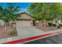 View of a well-maintained single-story home with a spacious two-car garage and lovely front yard landscaping at 8128 Devils Canyon St, North Las Vegas, NV 89085