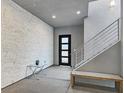 Modern entryway with a unique stone accent wall, bench, and staircase with metal railing at 881 Barrhead Ave, Henderson, NV 89012