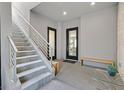 Welcoming entryway with a staircase, glass doors, seating, and modern finishes at 881 Barrhead Ave, Henderson, NV 89012